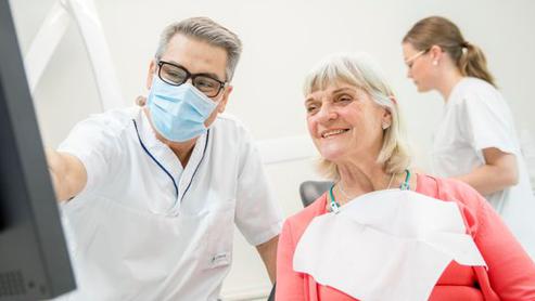 Tandläkare och patient vid dator