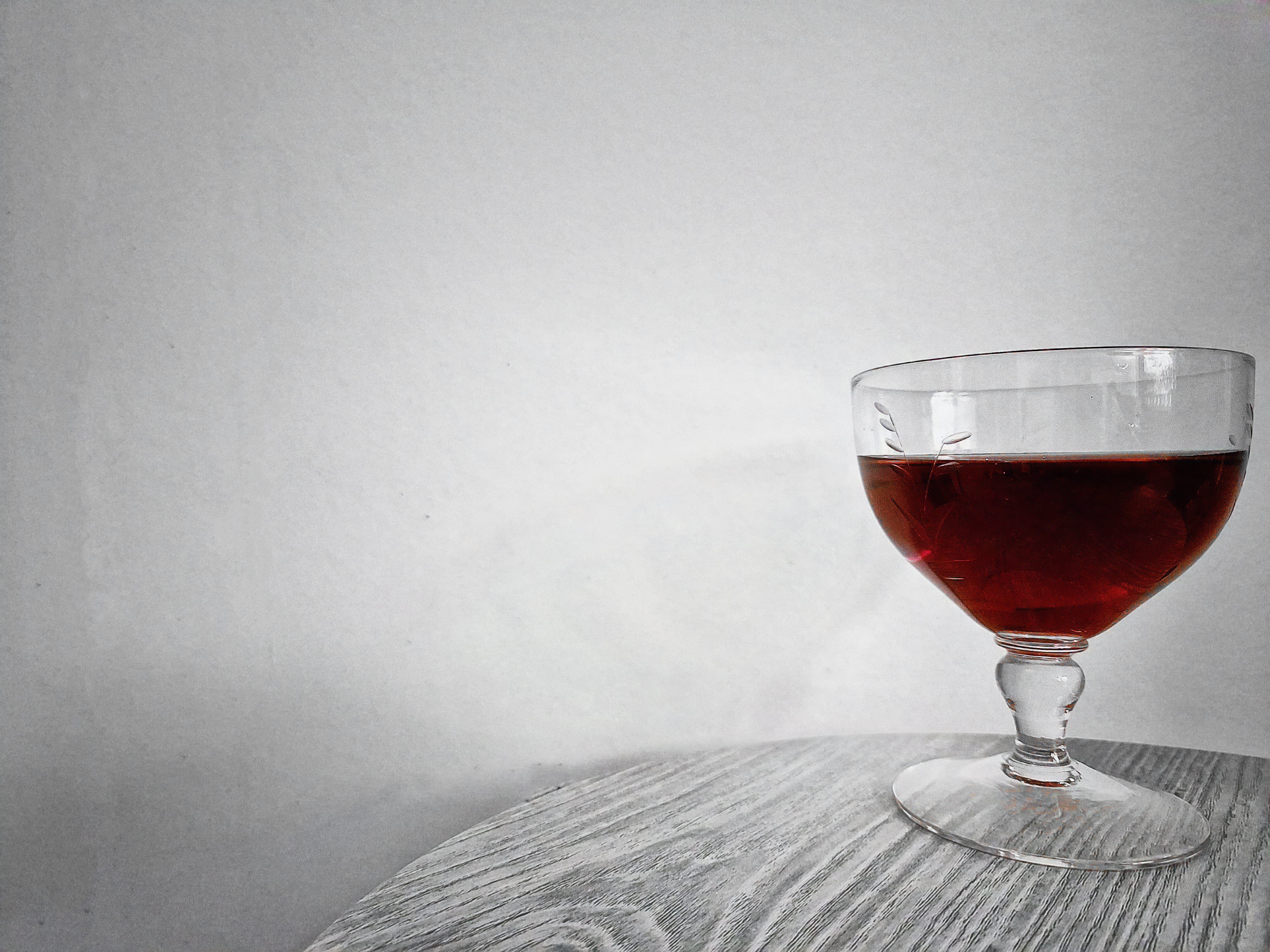 Vinglas med rödvin mot svartvit bakgrund