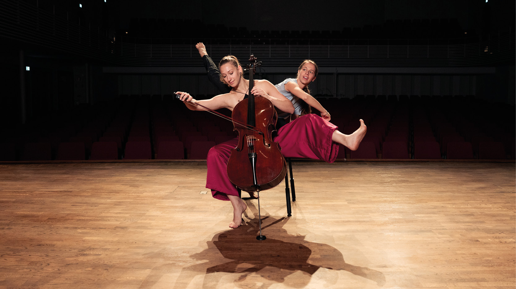 musiker med cello med dansare i bakgrunden